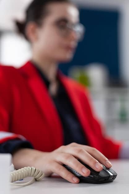 A close-up of a person's hands typing on a keyboard while speaking on a headset, with a focused expression. The background is a bustling call center environment.