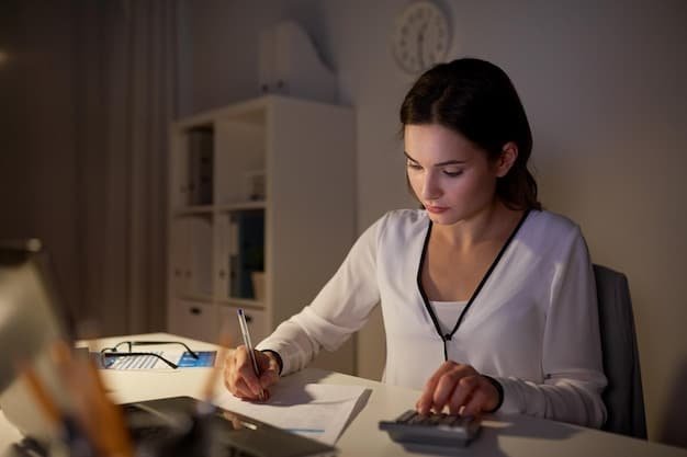 A person reviewing tax documents and using a calculator, in a brightly lit workspace.